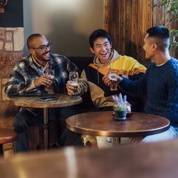 in the cozy ambiance of a pub in northumberland, england a small group of men are gathered around a table enjoying pints of beer, they are wearing casual clothing and smiling while unwinding and having a chat, the pub is dog friendly