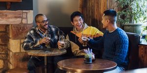 in the cozy ambiance of a pub in northumberland, england a small group of men are gathered around a table enjoying pints of beer, they are wearing casual clothing and smiling while unwinding and having a chat, the pub is dog friendly