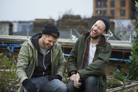 men sitting in urban roof garden laughing