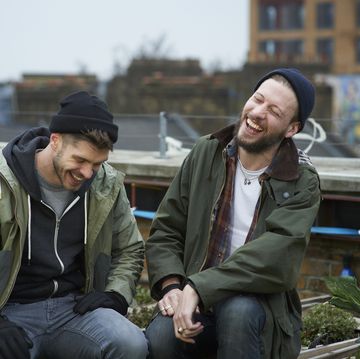 men sitting in urban roof garden laughing