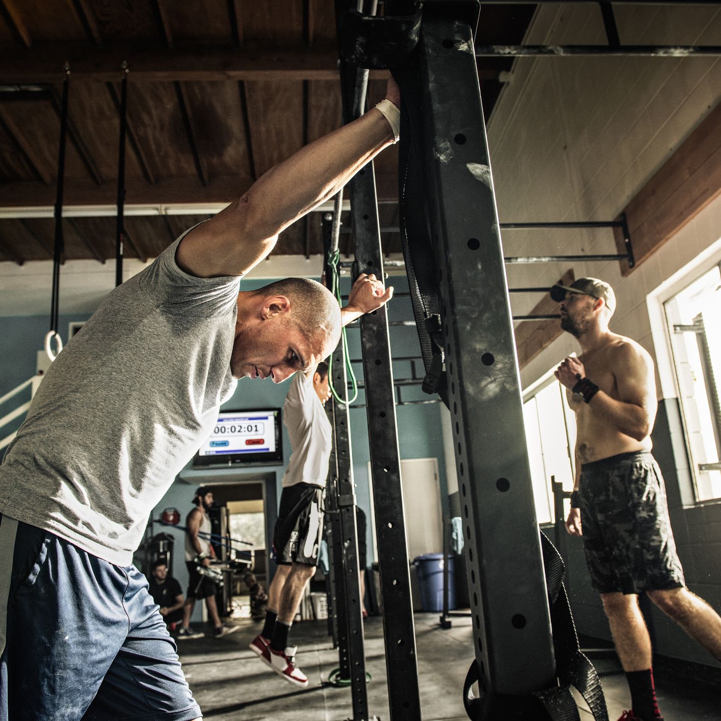 Men training on exercise bar in gymnasium