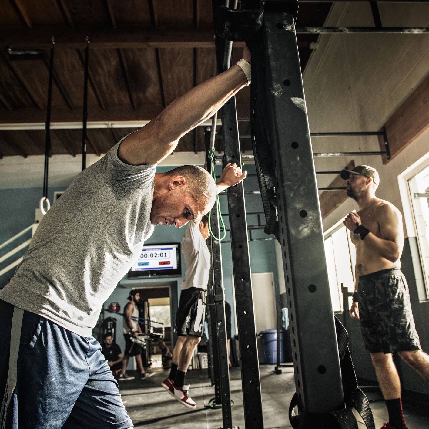 Men training on exercise bar in gymnasium