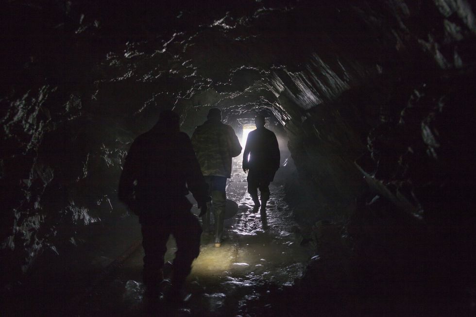 men walking in dark cave