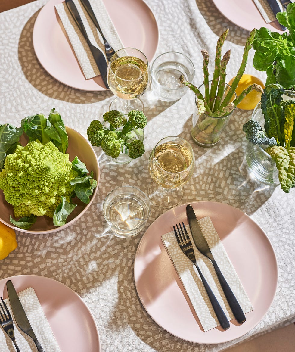 menaje de mesa con platos rosas y mantel beige con puntitos