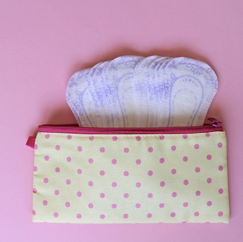 menstrual bag with sanitary napkins on pink background