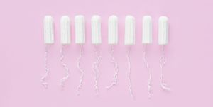 Menstrual period concept. Woman hygiene protection. Cotton tampons on pink background. Top view, flat lay.