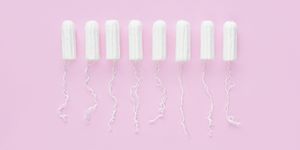 Menstrual period concept. Woman hygiene protection. Cotton tampons on pink background. Top view, flat lay.