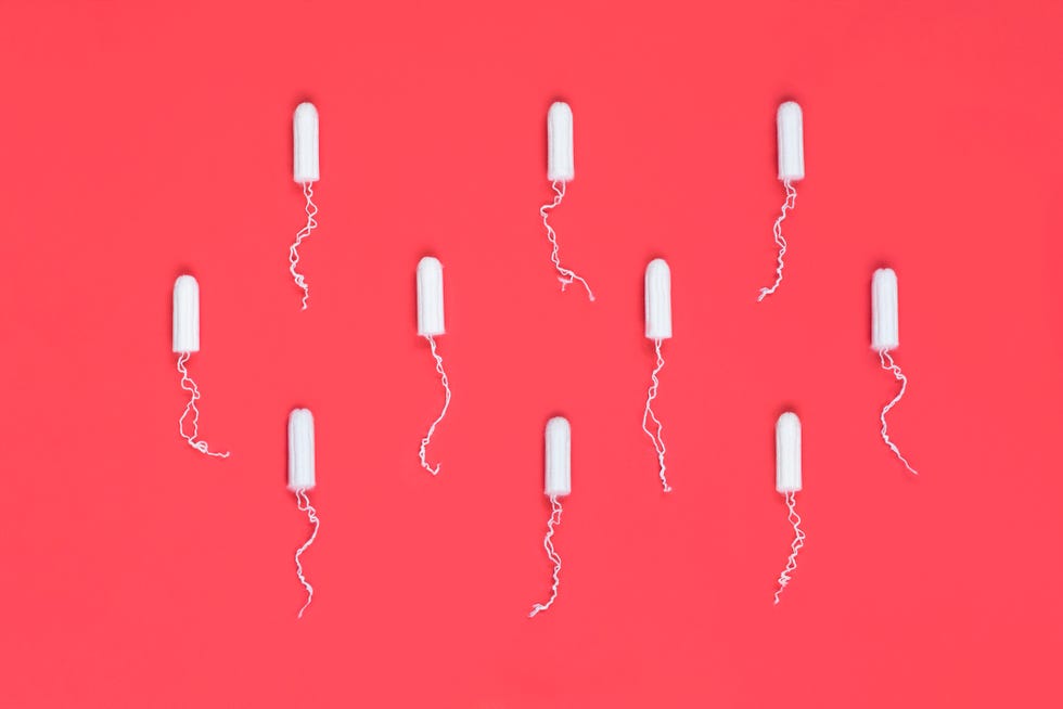 Menstrual period concept. Woman hygiene protection. Cotton tampons on red background. Top view, flat lay.