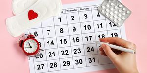 menstruation calendar with pads, alarm clock, hormonal contraceptive pills female's menstrual cycle concept menstrual retardation concept