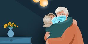 a senior couple hugs together after quarantine during the covid 19 pandemic shows seniors wearing a protective facial mask for protection themselves from the coronavirus in the new normal life concept