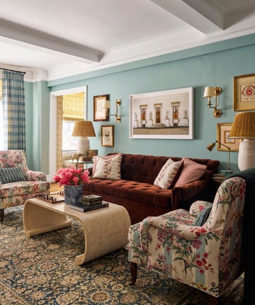 living room with solid colored couch, chairs with floral fabric, and coffee table