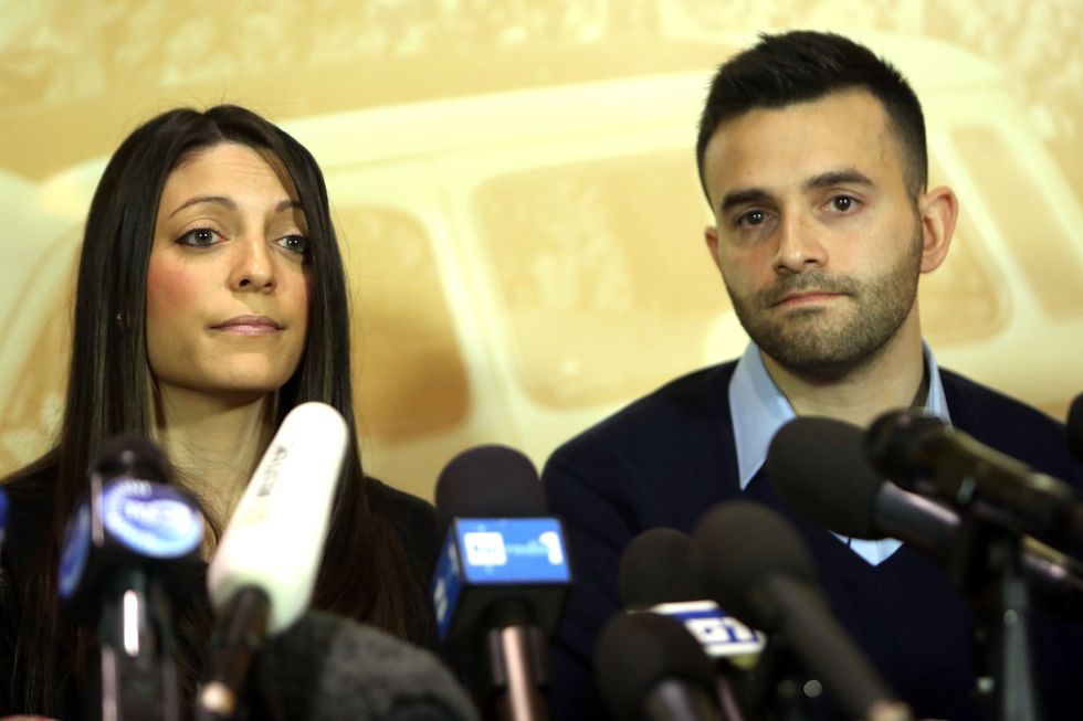 woman and man sitting at a table with microphones in front of them
