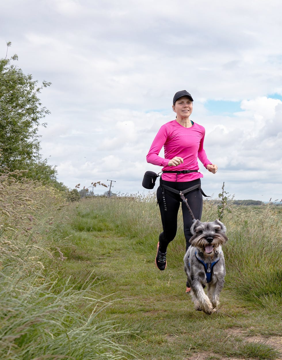 woman running with a dog in a rural environment