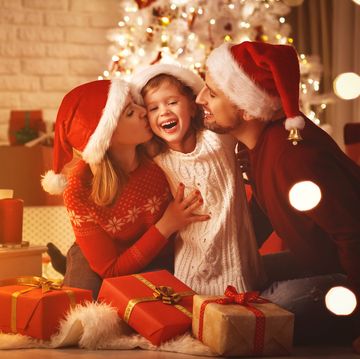 merry christmas happy family mother father and child with gifts near tree