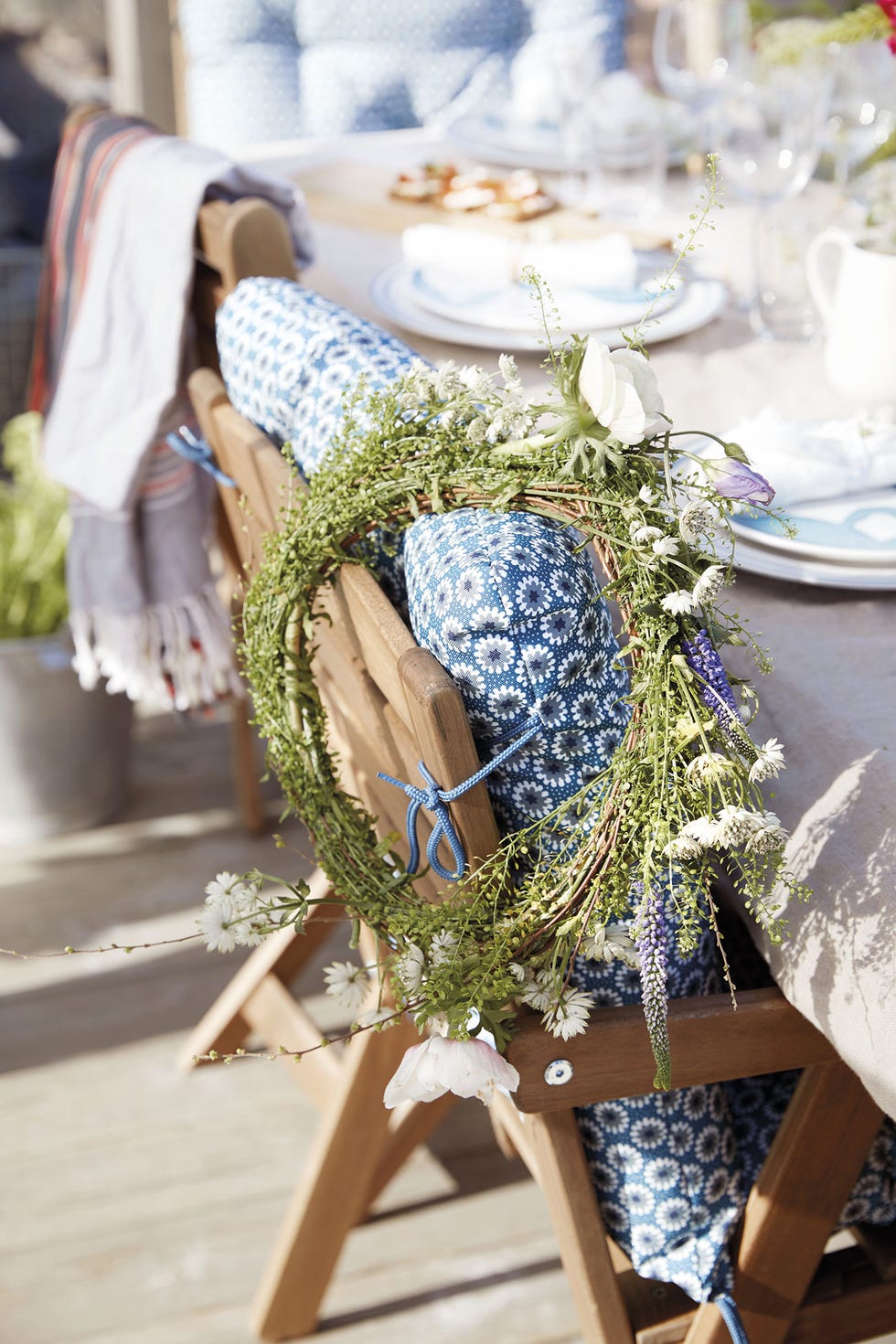 mesa de verano con sillas de madera decoradas con flores