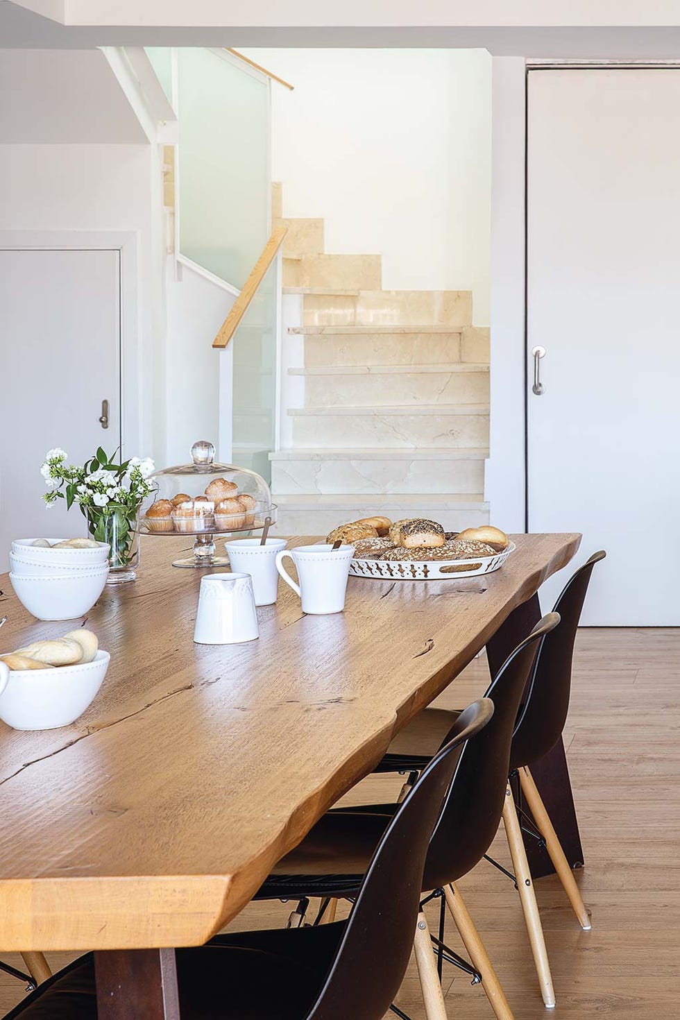 comedor con gran mesa de madera y patas en negro