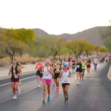 participants running in a marathon on a road with mountains in the background participants running in a marathon on a road with mountains in the background