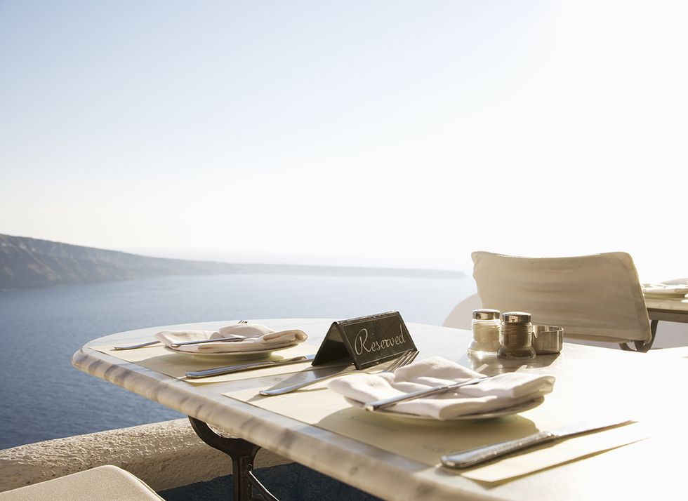 mesa reservada en una terraza frente al mar en santorini, grecia