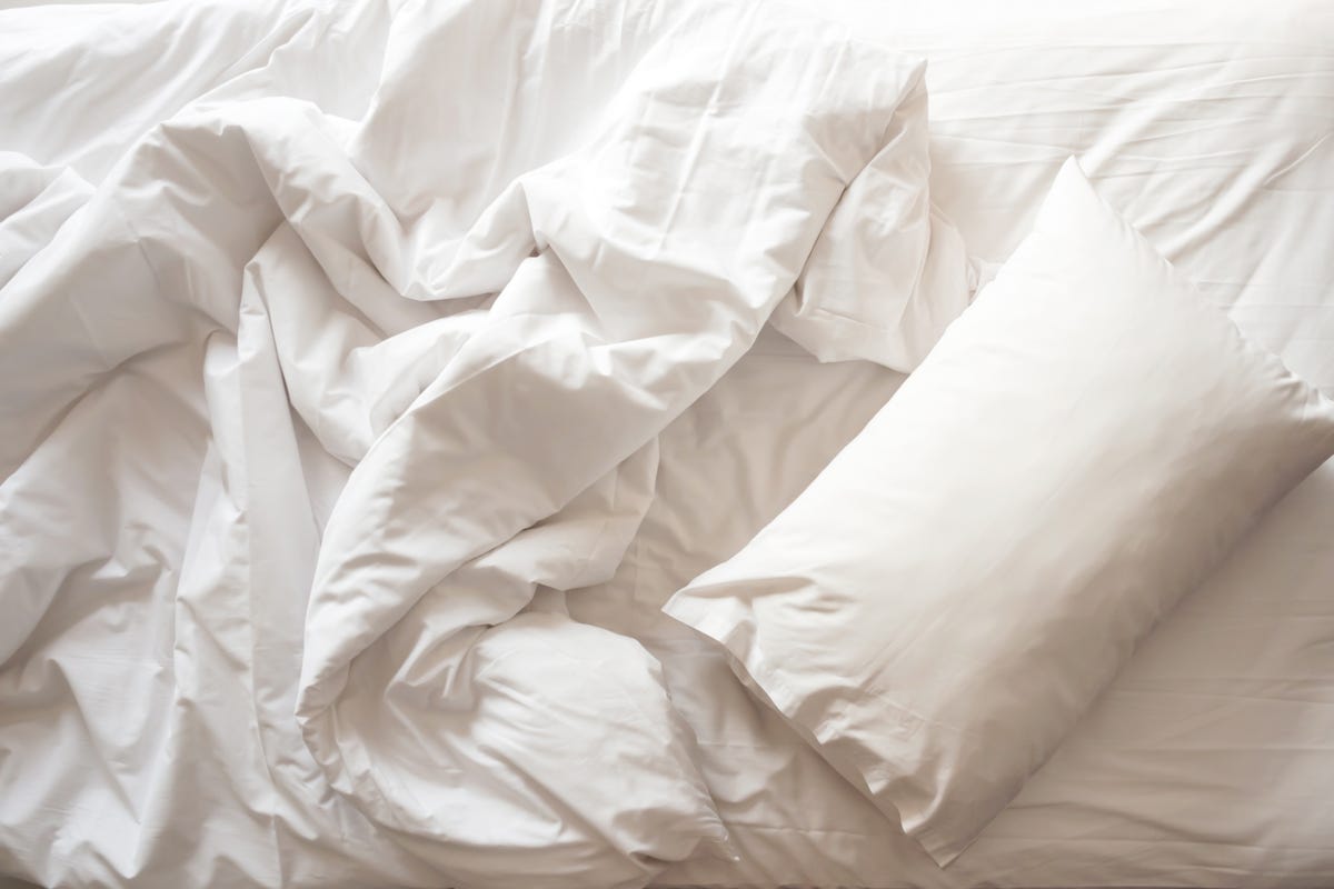 messy bed white pillow with blanket on bed unmade top view