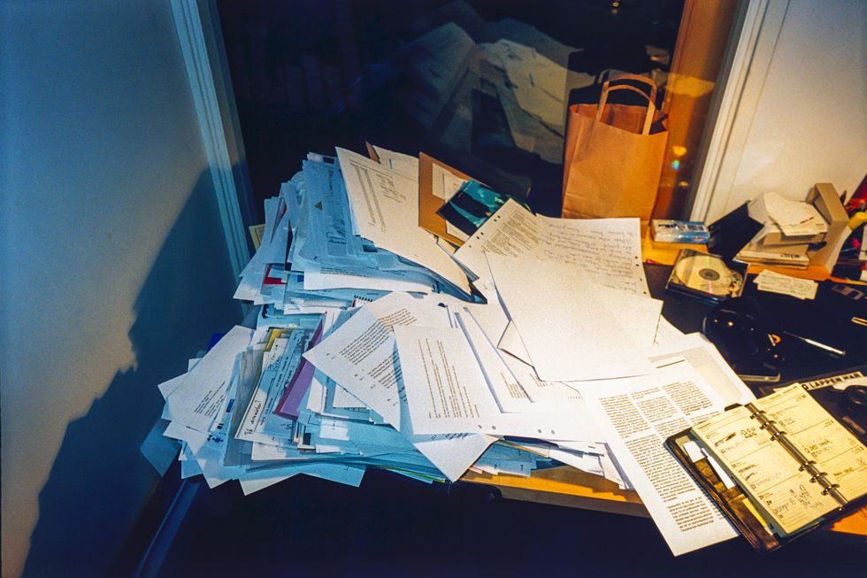 messy office desk piled with paperwork