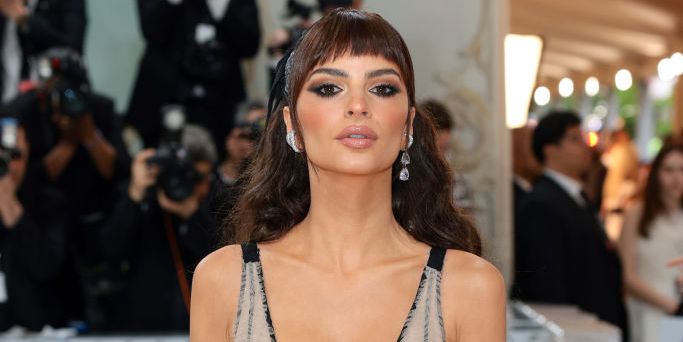 Emily Ratajkowski wears leather, lace-up corset dress with *the* biggest side slit