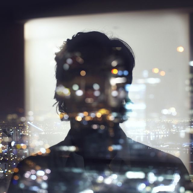 silhouette on man with bright city lights