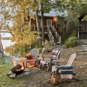 rustic fire pit with adirondack chairs at lake cabin