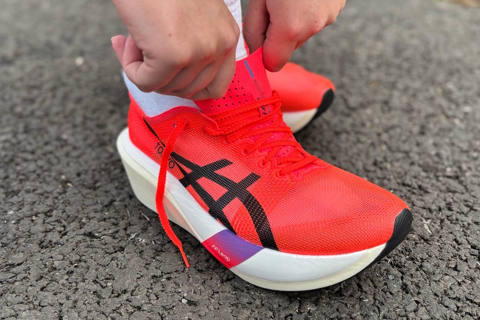 person putting on a red running shoe