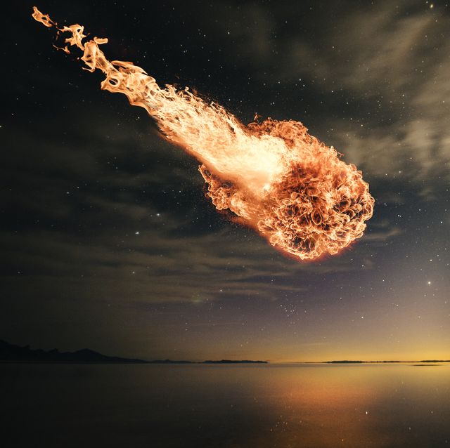 interstellar meteor falling through starry night sky over water