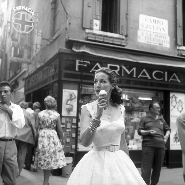maria félix eating an ice cream in front of a pharmacy