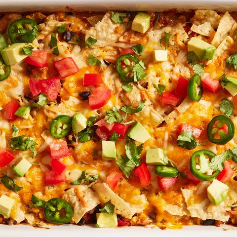 mexican chicken casserole topped with diced tomatoes, jalapenos and avocado