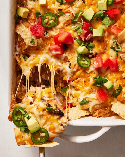 mexican chicken casserole topped with diced tomatoes, jalapenos and avocado