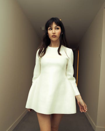 a person wearing a white dress standing in a hallway