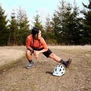 mountain biker stretching to avoid leg cramps