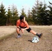 a mountain biker stretching her leg