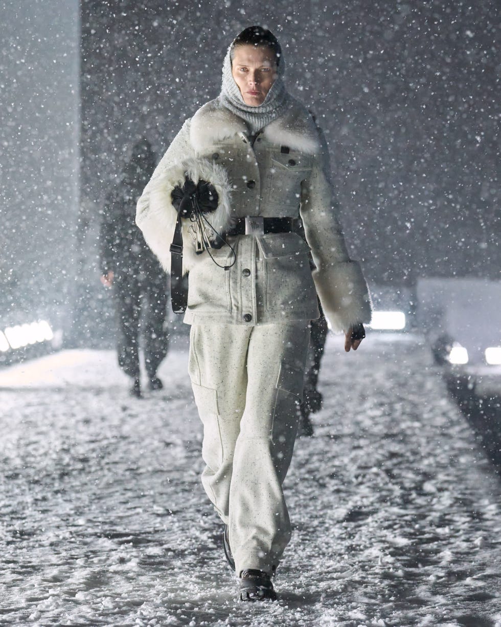 a model walking on a snowcovered runway in a winter fashion ensemble