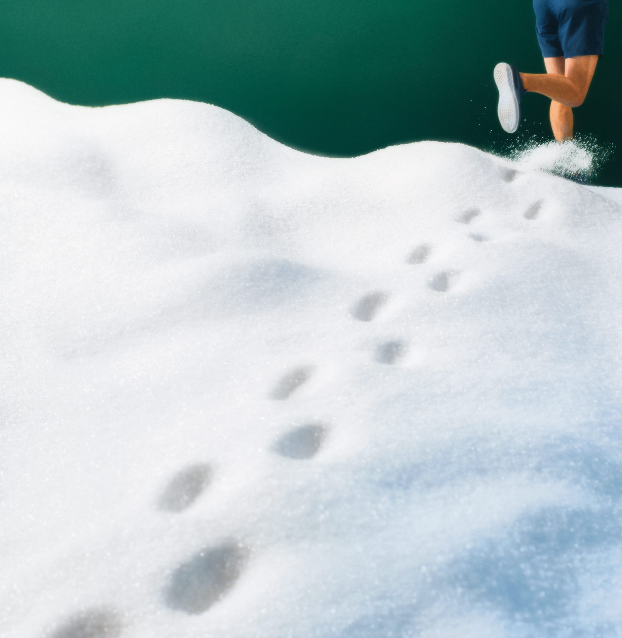 a person running on a snowy surface with visible footprints