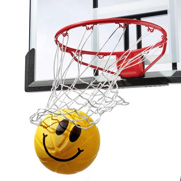 a basketball with a smiley face going through the net and a shoe with a smiley face