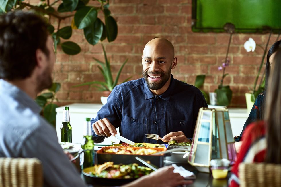Candid portrait of attractive African American man having meal with friends