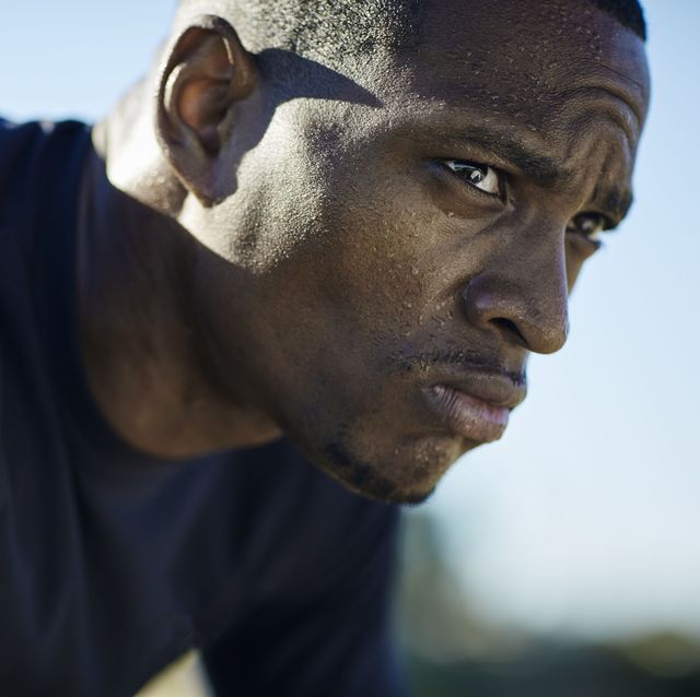 black man wearing black tshirt with visible sweat on face