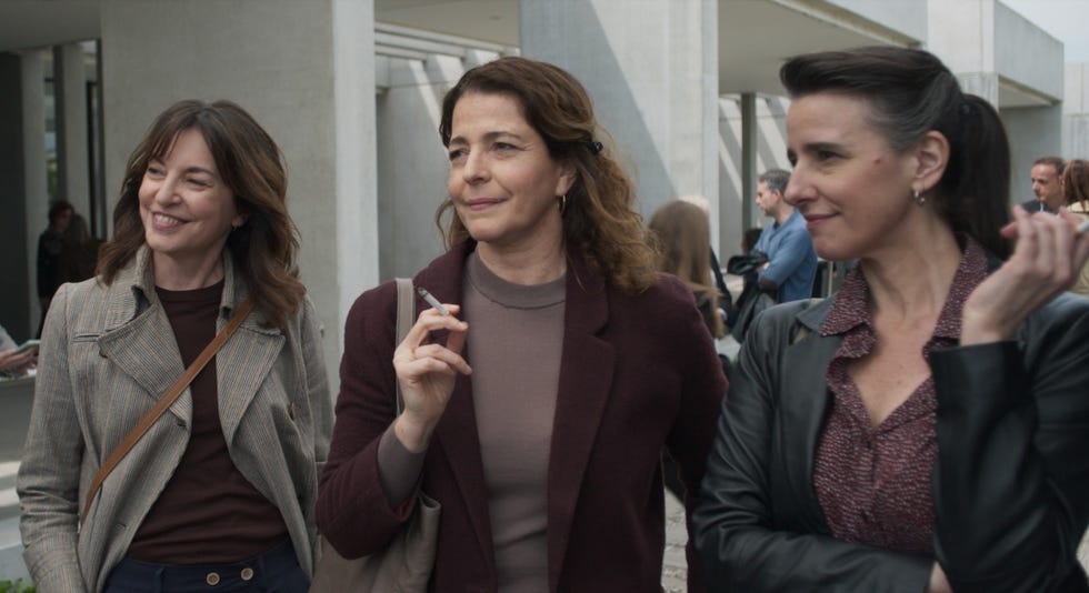 group of women standing together in a public place engaged in conversation