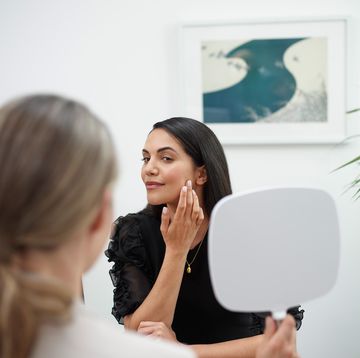 vrouw kijkt naar eigen gezicht in spiegel