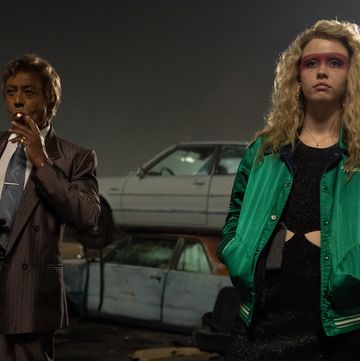 giancarlo esposito smoking a cigarette and standing next to mia goth in a scene from maxxxine