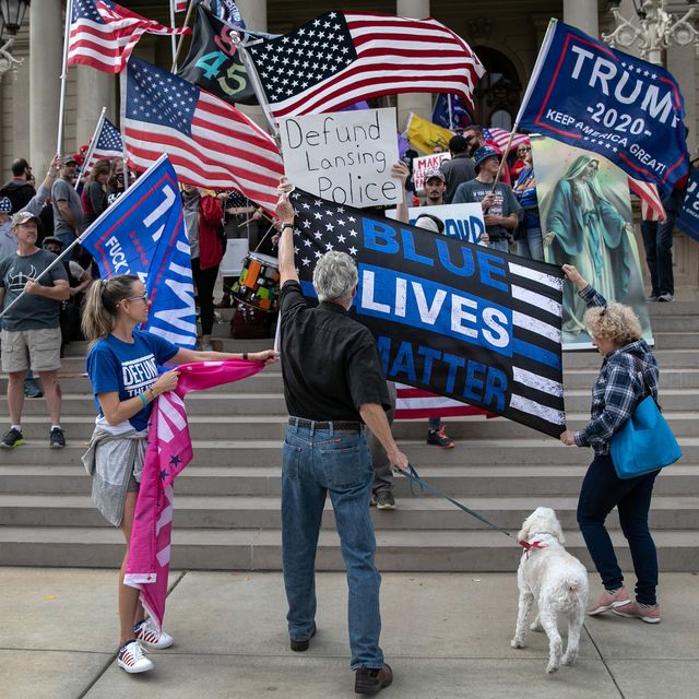 lansing, michigan   november 08 trump supporters try to block a "defund lansing police" sign during simultaneous demonstrations at the michigan state capitol on november 08, 2020 in lansing, michigan right wing militia members had pledged to attend the "stop the steal" demonstration by trump supporters, claiming the presidential election had been stolen photo by john mooregetty images