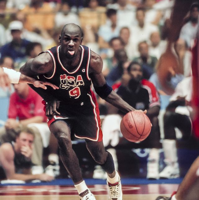 michael jordan sticking his tongue out while dribbling a basketball