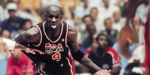 michael jordan sticking his tongue out while dribbling a basketball