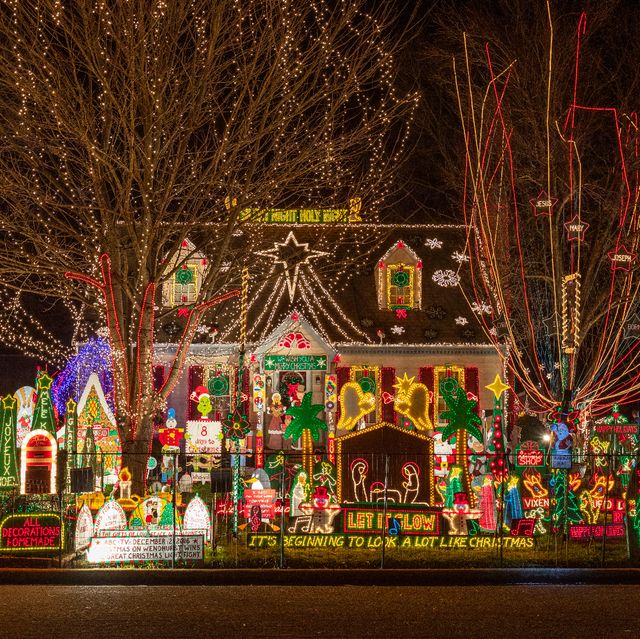 house overwhelmed by christmas light displays over it and in the yard
