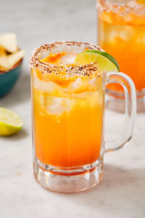 michelada in a glass with a chili salt rim garnished with a lime