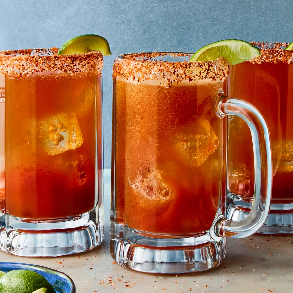michelada in a glass with a tajin rim and lime garnish