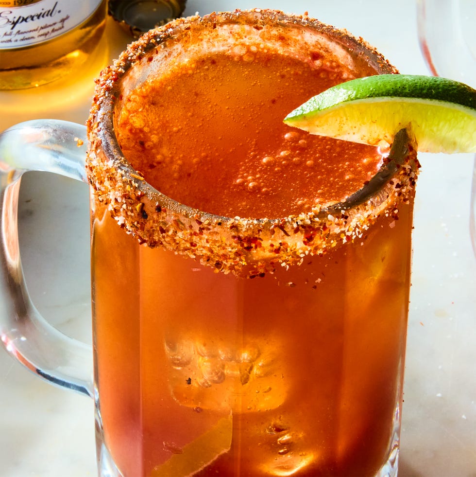 michelada in a glass with a tajin rim and lime garnish